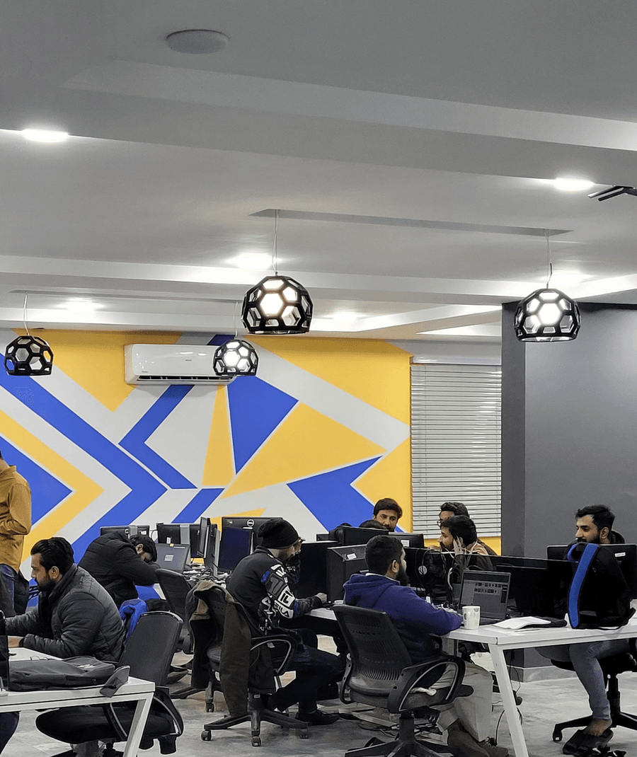 A colourful office floor at Visiomate, with a yellow and blue graphic wall